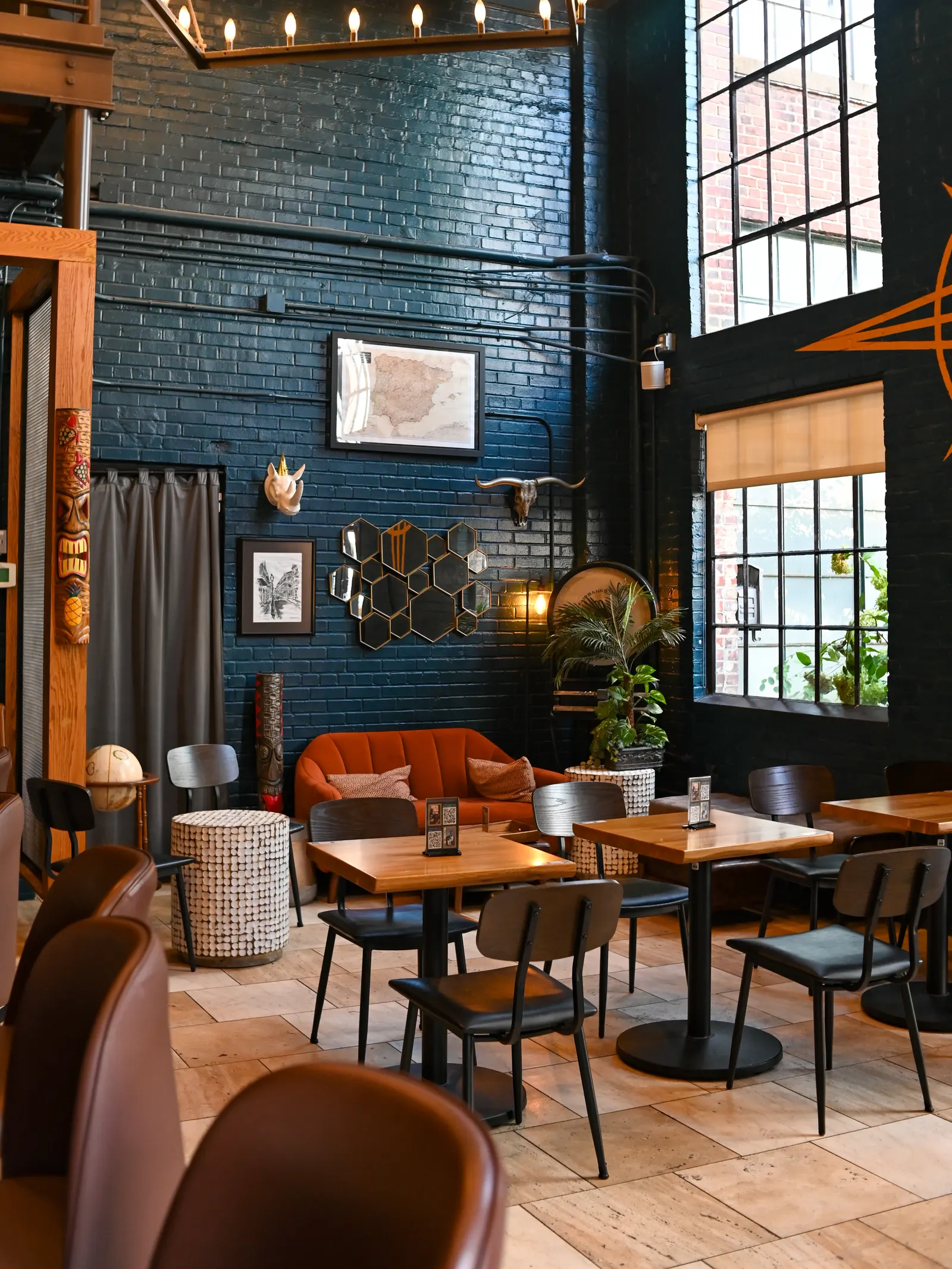 Elsewhere lounge seating beneath candle-style lights and tall industrial windows