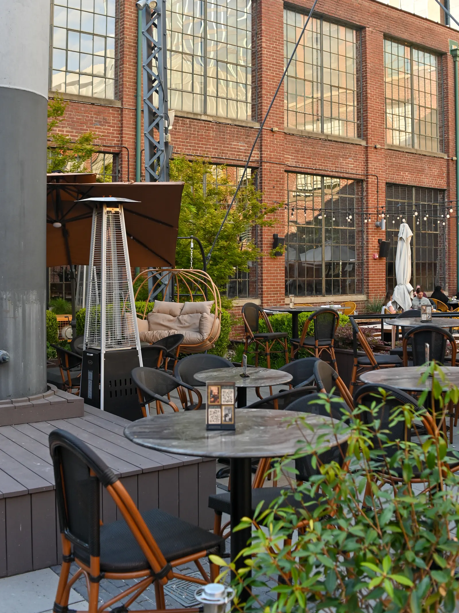 Courtyard tables and a hanging chair beneath the South End water tower