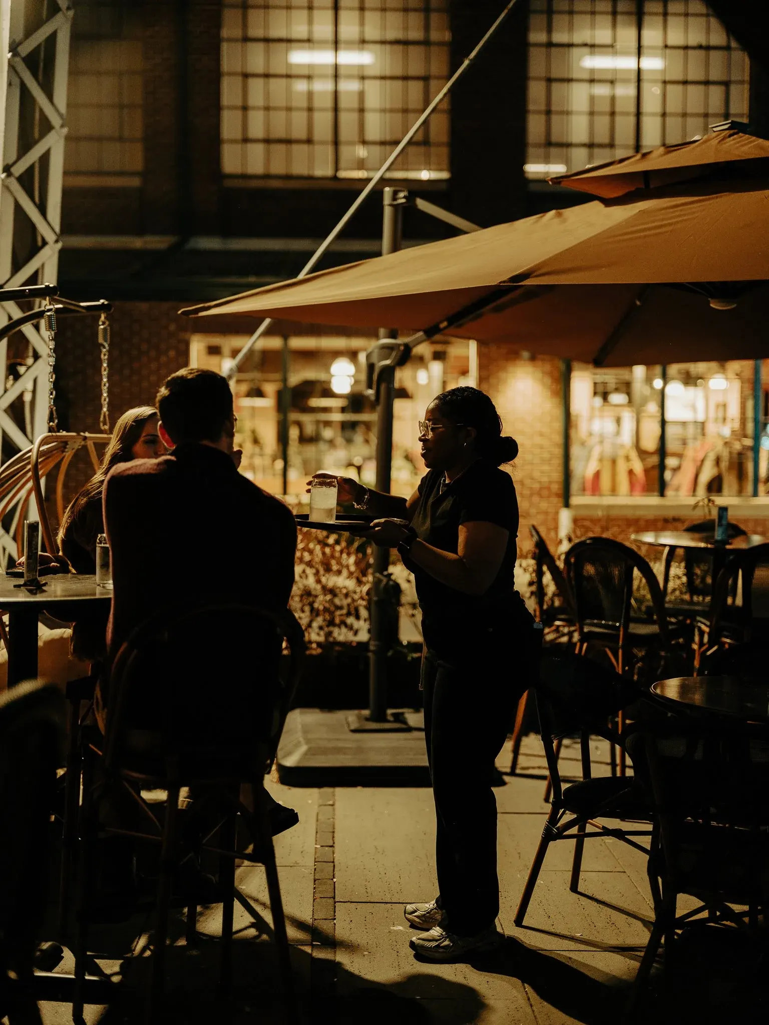 Guests seated at the Elsewhere courtyard bar